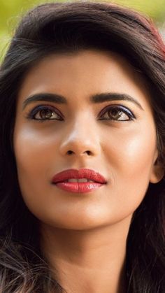 a woman with long dark hair and red lipstick