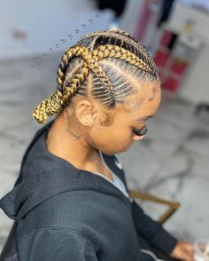 a woman with cornrows sitting at a table