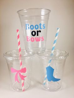 three plastic cups with straws and one has a princess crown on the side, two have blue and pink striped straws