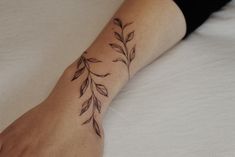 a woman's foot with a tattoo design on the left side of her arm