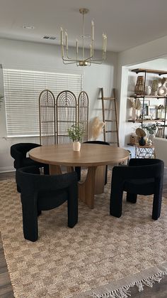 a dining room table and chairs in front of a window