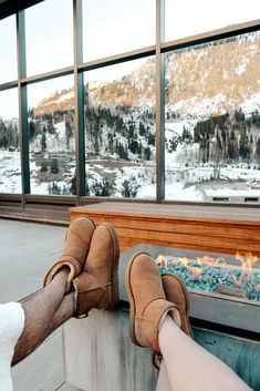 someone's feet resting on the edge of a fireplace