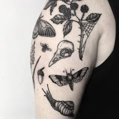 a woman's arm with tattoos on it, including moths and flowers in black ink