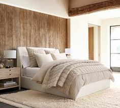 a bedroom with a large bed and wooden walls