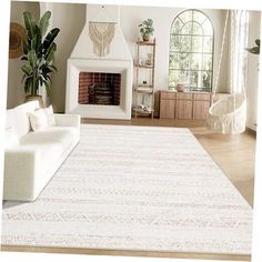 a living room filled with furniture and a white rug on top of a hard wood floor