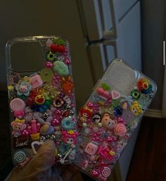 someone is holding up their phone case with many different items on it, including buttons and charms