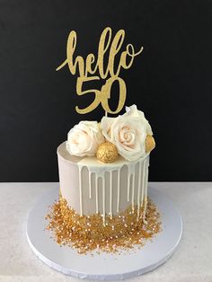 a cake with white frosting and gold sprinkles