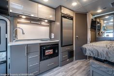 the interior of a travel trailer with an oven and sink