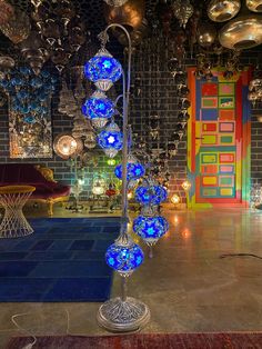 a room filled with lots of lights and ornaments on the wall next to a blue rug