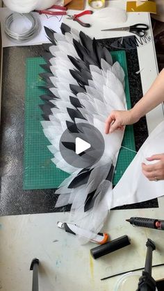 someone is making an art project with feathers