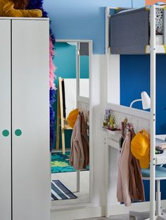 a bedroom with blue and white walls, furniture and accessories on the shelves in front of it