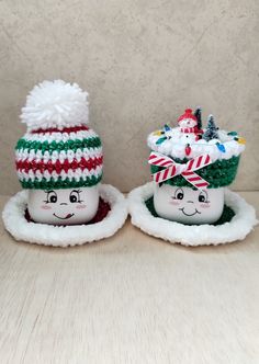 two snowmen with hats on sitting next to each other