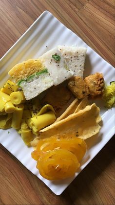 a white plate topped with food on top of a wooden table