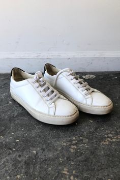 Woman by Common Projects Sneakers. White lace-up sneaker with black back panel. Size Womens 36. Made in Italy. Approx. Measurements Heel to Toe: 10" Width: 4" Common Projects Sneakers, Common Projects, Black Back, Back To Black, Sneakers White, White Lace, In Italy, Lace Up, Italy