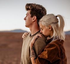 a man carrying a woman on his back in the middle of an open desert area