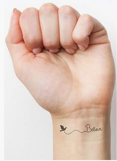 a hand holding up a small tattoo on it's wrist, with the word temporary tattoos