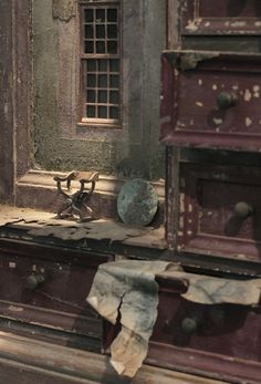 an old dresser is sitting in front of a window