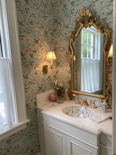 a bathroom sink sitting under a mirror next to a window