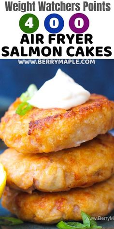 four air fryer salmon cakes stacked on top of each other with lemon wedges