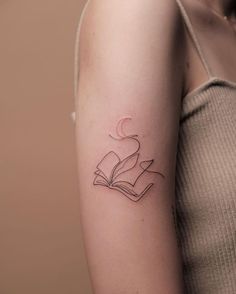 a woman with a book tattoo on her arm