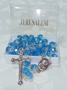 "Rosary of the Holy Land with the soil of Jerusalem Do not waste this blessing and get it now   Round Beads Necklace with Jerusalem Soil  Cross From The Holy Land This fine Rosary is Top quality has  silver tone metal Catholic Crucifix  with word \"Jerusalem\" engraved convexly  on the back, and medal  (one side-icon of Virgin Mary, other side - Holy Soil of Jerusalem  with the words \"Terra Jerusalem\"). The purpose of the Rosary is to help  keep in memory certain principal events  in the history of salvation,  and to thank and praise God for them. First are the introductory prayers:  one Apostles Creed, one Our Father (Lord's Prayer),  three Hail Mary's one Glory Be. measuring 21 inches long,  each rosary 36   grams" Blue Cross Jewelry With 8mm Beads, Silver Rosary With Faceted Beads As Gift, Blue Crucifix Necklace For Spiritual Wear, Blue Cross Rosary As Gift, Silver Rosary With Faceted Beads For Gift, Blue Rosary With 8mm Beads In Cross Shape, Blue Spiritual Rosary With Gemstone Beads, Blue Rosary With 8mm Beads And Crucifix, Blue Cross-shaped Jewelry With 8mm Beads