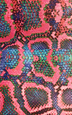 a close up view of a pink, blue and green patterned material with circles on it