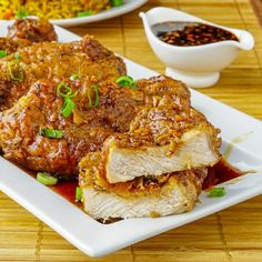 two white plates topped with meat covered in sauce