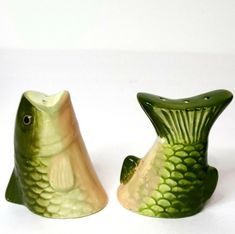 two green fish shaped vases sitting next to each other