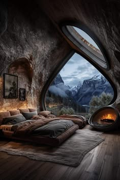 there is a bed in the room with an open window and mountain scenery outside it