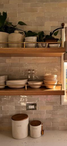 the shelves are filled with bowls and plates on them, along with other kitchen items