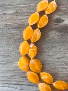 This vibrant chunky necklace is sure to brighten up any look! Crafted with a mix of orange & white swirl acrylic beads and glass spacers, its aesthetic is unmissable without feeling heavy.- Bead size is 1.25" across - Shortest strand measures 18.75 - 20.75" (length varies depending on clasp chosen) - 2 Strand necklace- Lobster claw clasp is gold stainless steel (sterling silver, stainless steel, gold filled are also available)- 2" gold stainless steel extender chain- Lead free pewter connectorThe mannequin's neck size is 14.5". The length can be customized. We use the highest quality findings to ensure a piece that will last for years to come. DLD jewelry comes with a lifetime guarantee. This necklace is handmade in the USA. Dana LeBlanc Designs- Handmade Jewelry Orange Hand-strung Multi-strand Jewelry, Cheap Orange Multi-strand Necklaces, Yellow Multi-strand Jewelry With Polished Beads, Orange Multi-strand Polished Beaded Necklace, Yellow Multi-strand Polished Beads Jewelry, Pearl Statement Necklace, Long Beaded Necklace, Beaded Statement Necklace, Brooch Necklace