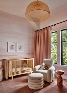 a baby's room with pink walls and furniture