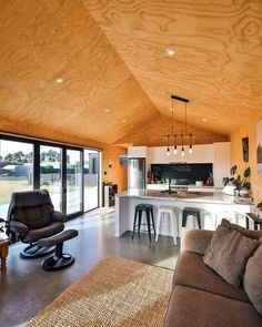 a living room filled with furniture next to a kitchen and an open concept dining area