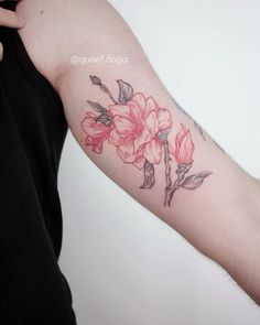 a woman's arm with a flower tattoo on the left side of her arm