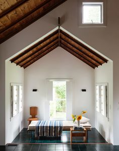 a living room filled with furniture and a wooden ceiling mounted to the side of a wall