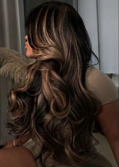 a woman with long, wavy hair and an angel wings behind her head is looking out the window