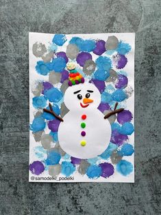 a paper plate with a snowman made out of blue and purple flowers on it