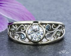 a close up of a ring with a flower in the background