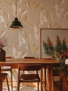 a dining room table with two chairs and a vase on the table next to it