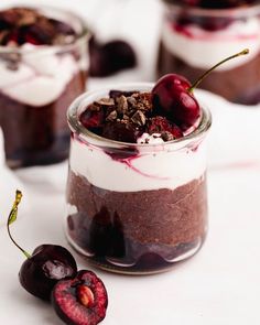 two desserts with cherries and whipped cream in them