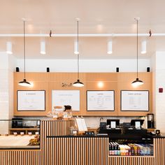 the interior of a coffee shop with menus on the wall and lights hanging from the ceiling