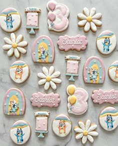 decorated cookies are arranged in the shape of letters, numbers and animals on a marble surface