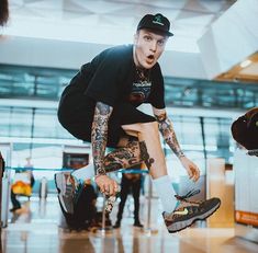 a man in black shirt and hat doing tricks on skateboard