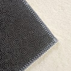 a black and white area rug on top of a carpeted floor with dots in the middle