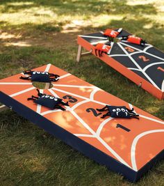 two orange and black cornhole boards sitting in the grass