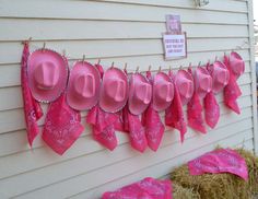 pink hats are hung on the side of a house