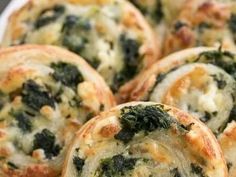 small pizzas with spinach and cheese are on a white plate, ready to be eaten