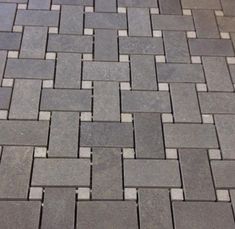 a close up view of a gray brick floor with white and black squares on it