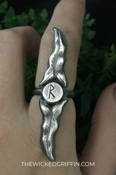 a person wearing a ring with the letter k on it