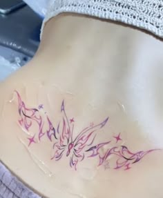 a woman's stomach with tattoos on it and purple stars in the bottom half